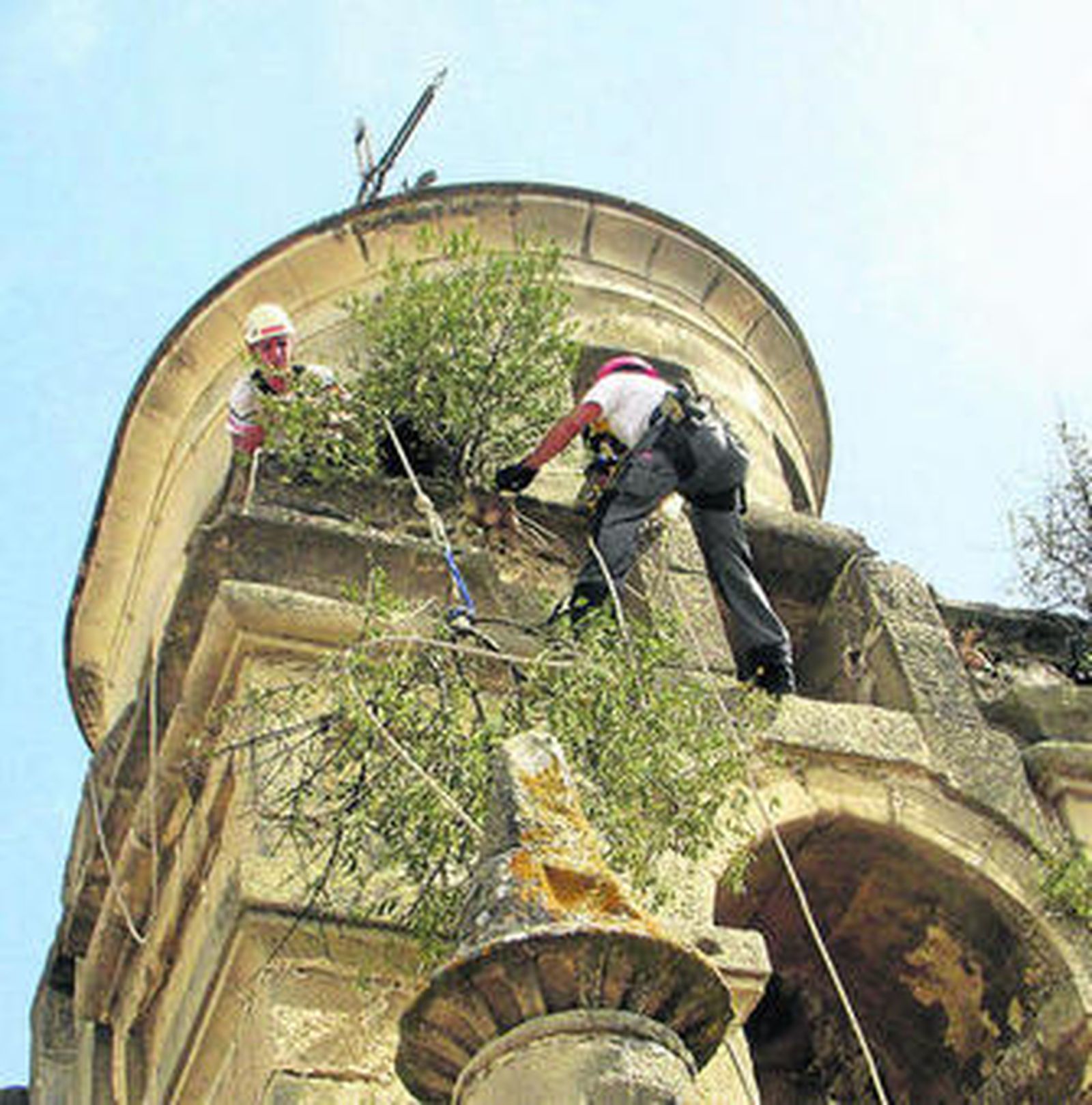 Especialistas en trabajos verticales limpiando el campanario este verano.