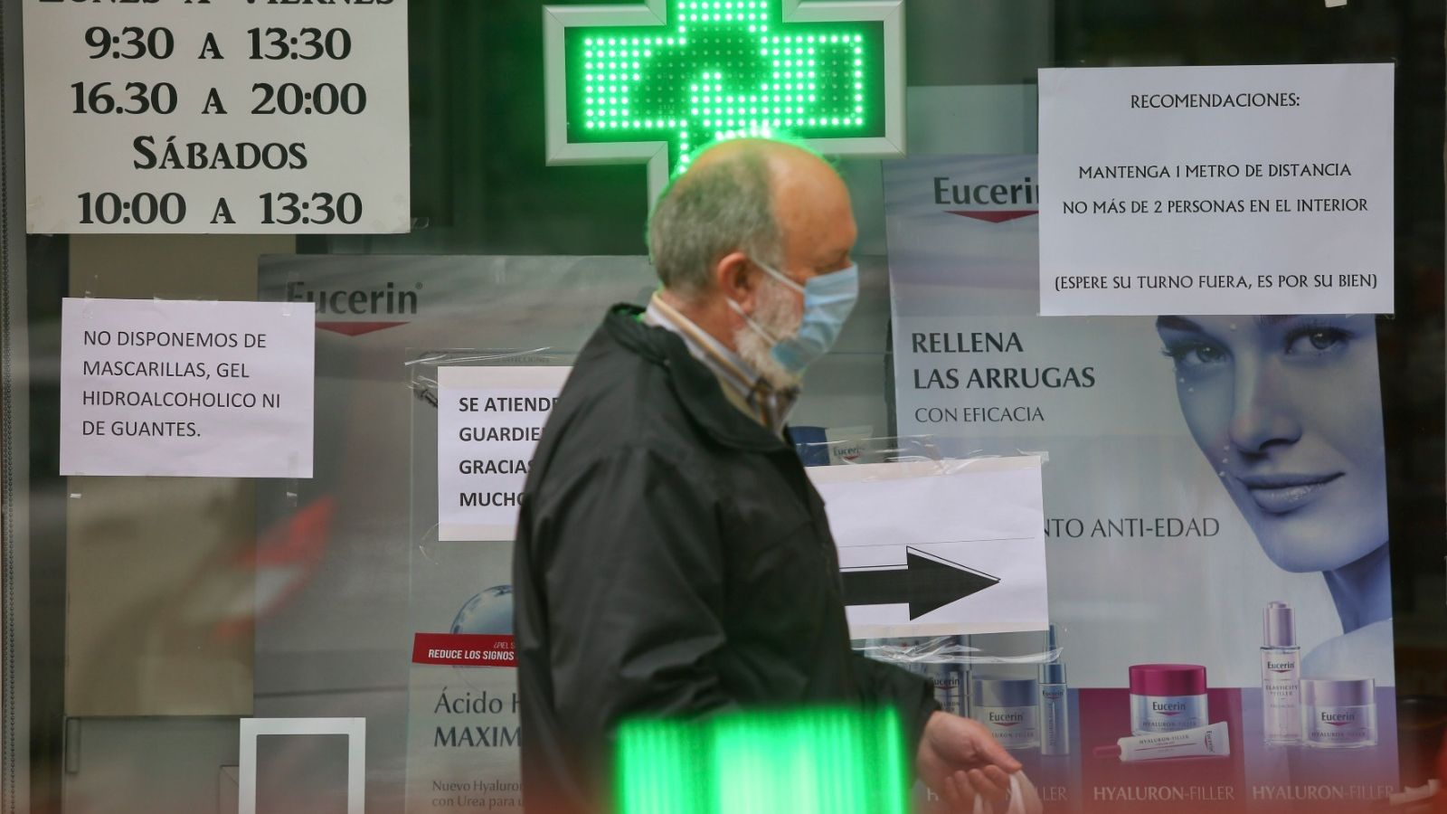 Un hombre pasa frente al escaparate de una farmacia.