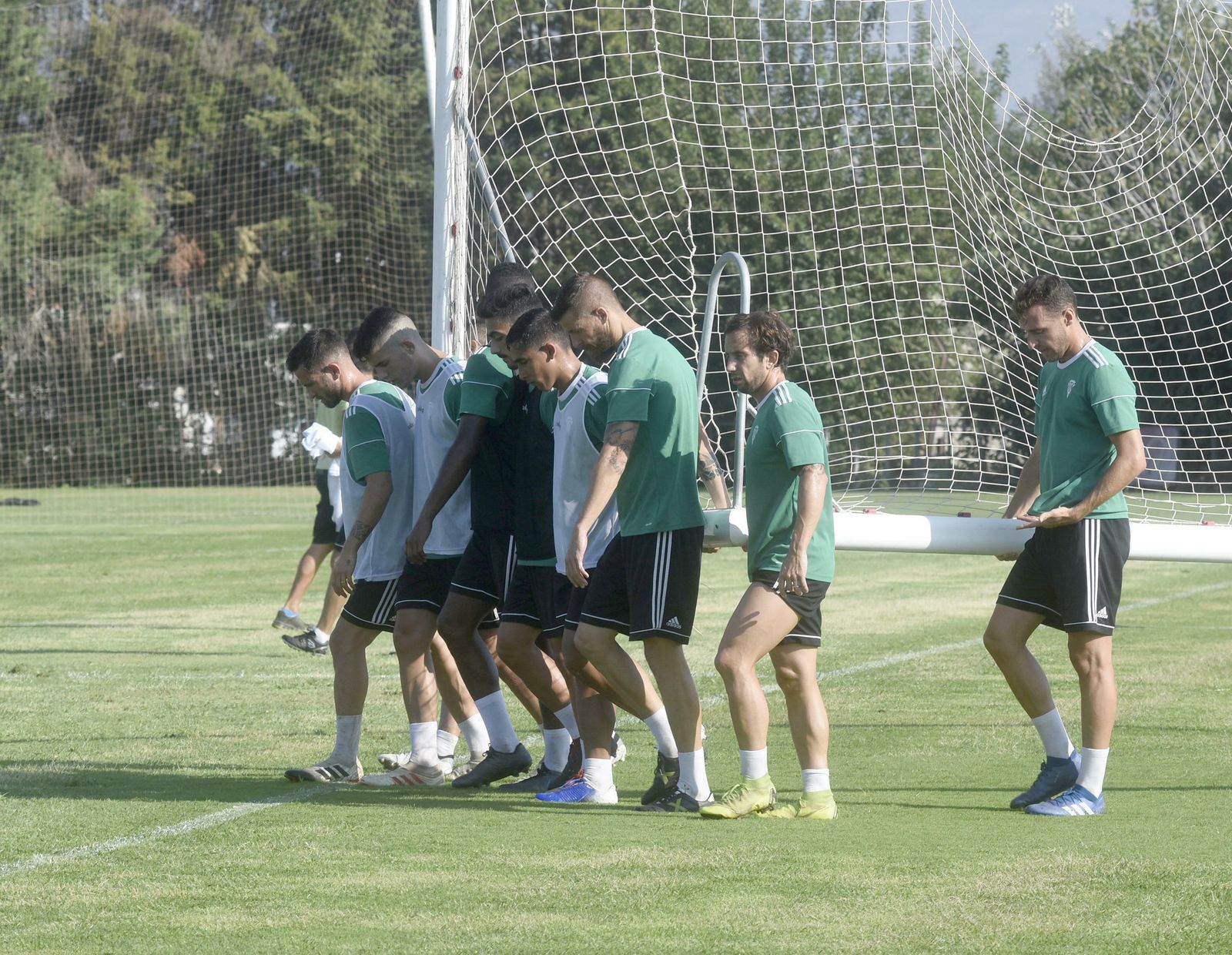 Los jugadores del Córdoba CF portan una portería durante una sesión en la Ciudad Deportiva.