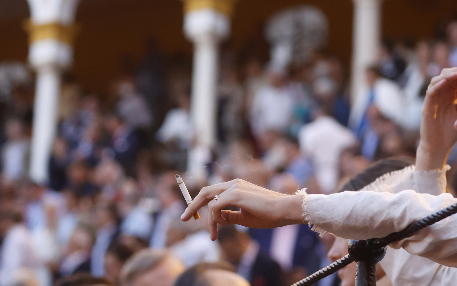 Una mujer sostiene con su mano un cirgarro.
