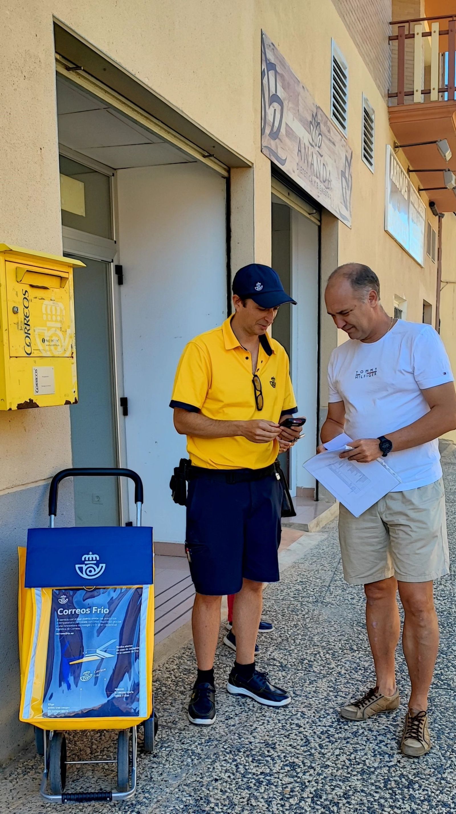 Un trabajador de Correos entregando una carta.