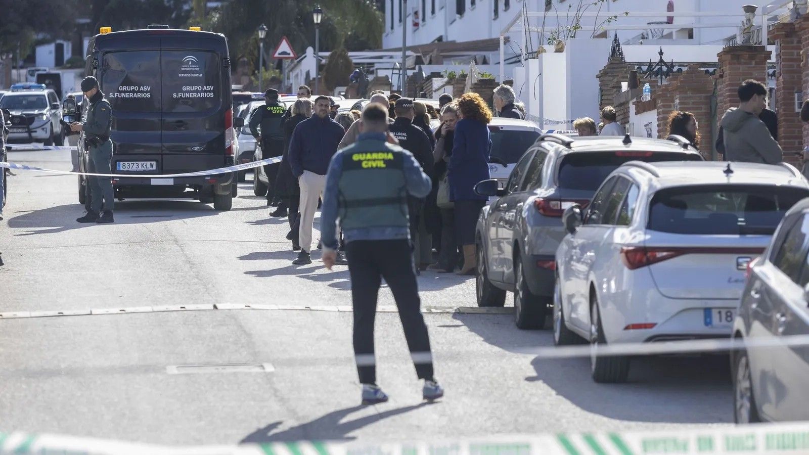 Efectivos de la Guardia Civil, Policía Local junto al coche fúnebre en la urbanización de Alhaurín el Grande.