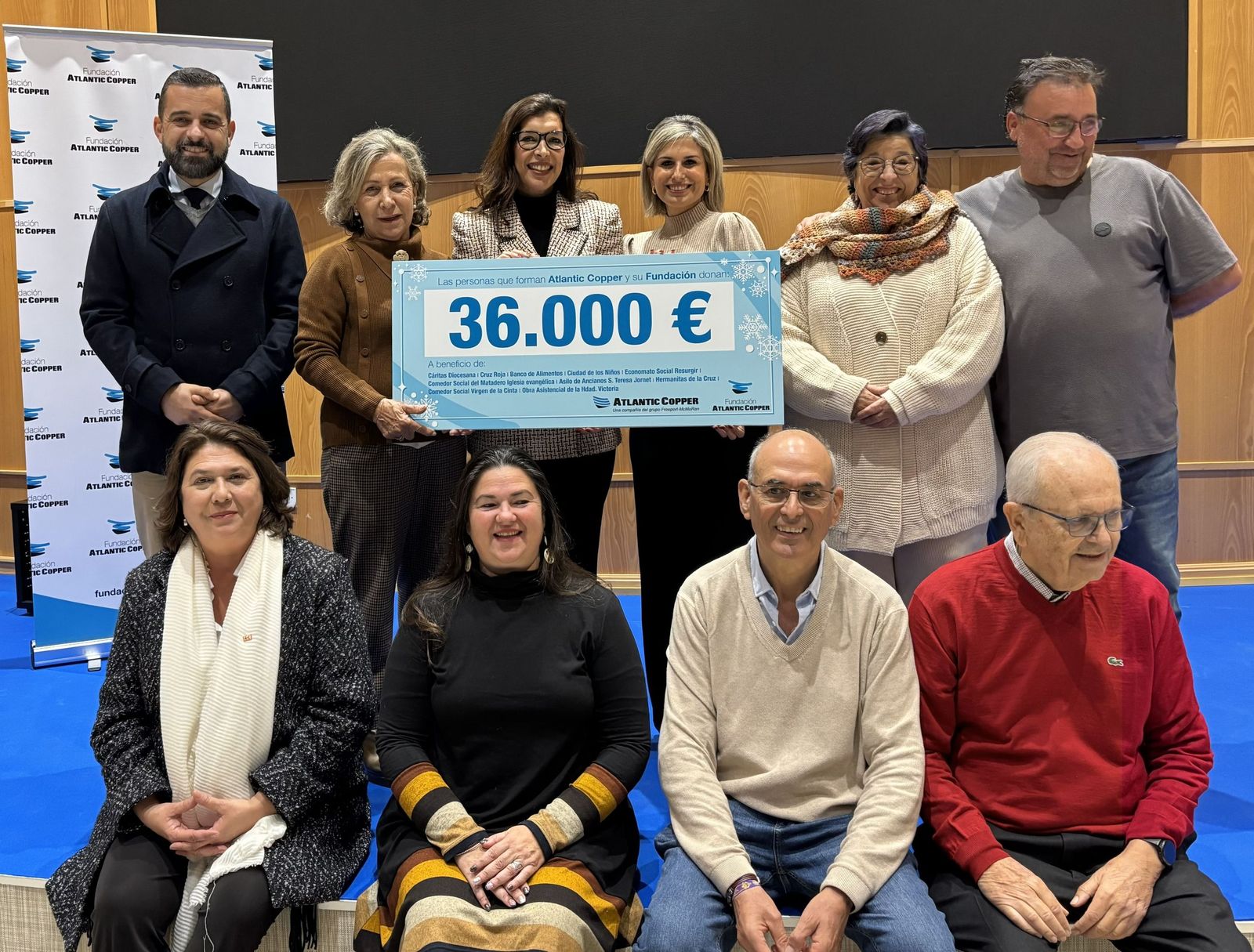 La directora de la Fundación Atlantic Copper, Ángeles Sánchez Cueca, posa con el cheque con representantes de diez entidades sociales de Huelva beneficiarias.