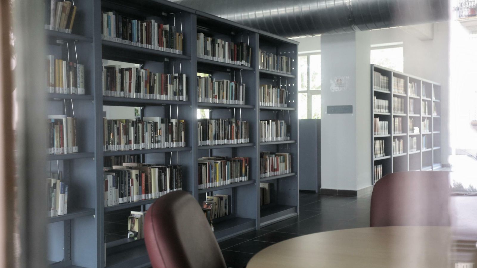 Los libros y el mobiliario aguardan la reapertura de la sala de lectura de la biblioteca.