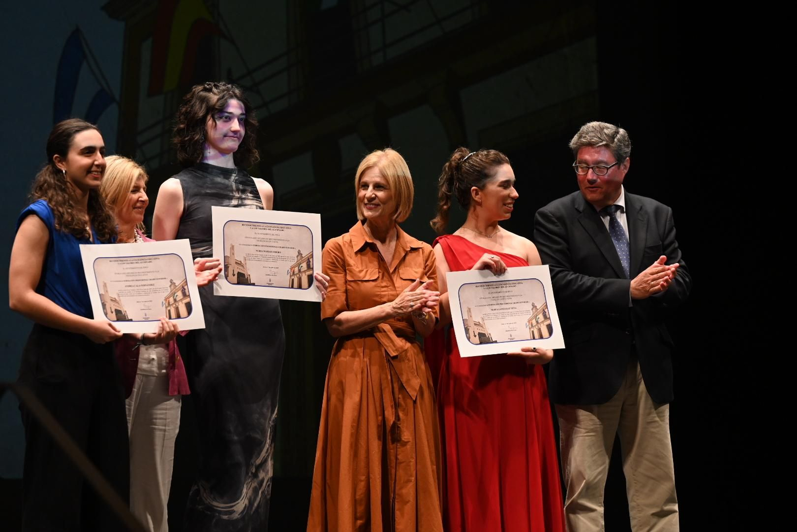 María José García-Pelayo, Isabel Paredes y José Ángel Aparicio, aplaudiendo a tres estudiantes galardonadas.