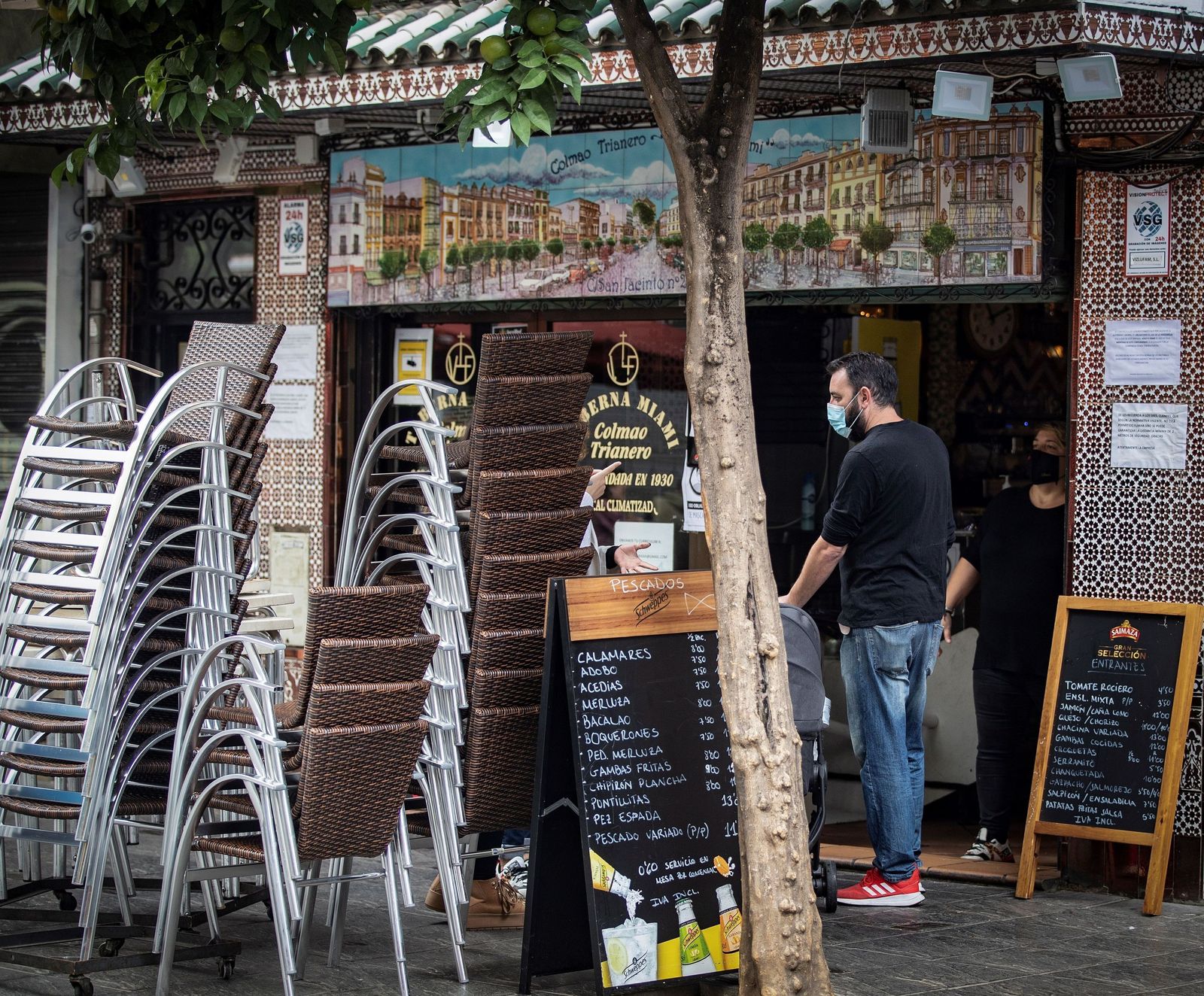 Una taberna de Triana, con las sillas de los veladores apiladas.