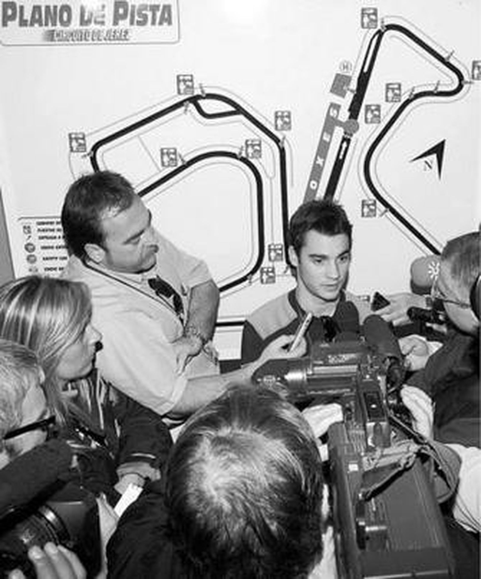 Dani Pedrosa, respondiendo a los periodistas con un plano del Circuito detrás.