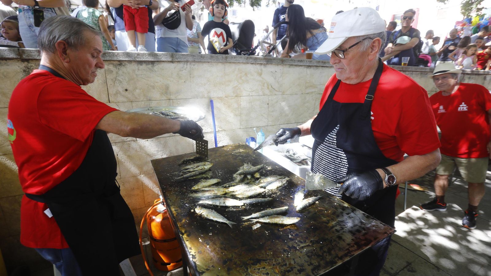 Colaboradores de la asociación vecinal San José Obrero preparando las sardinas.