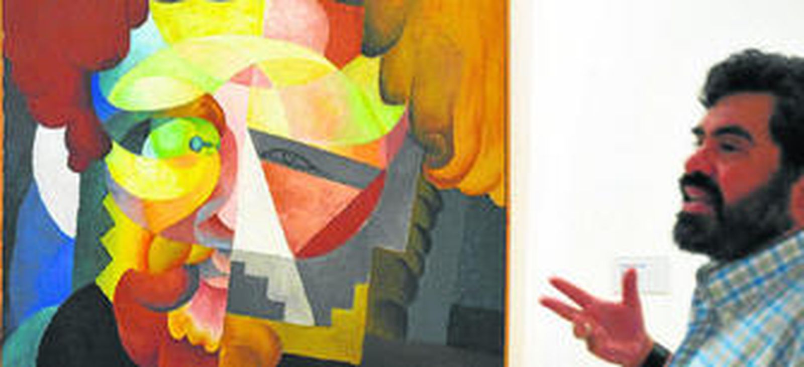 El comisario mexicano Luis-Martín Lozano, junto a una de las obras incluidas en la exposición, 'Retrato de M. A. Voloshin'.