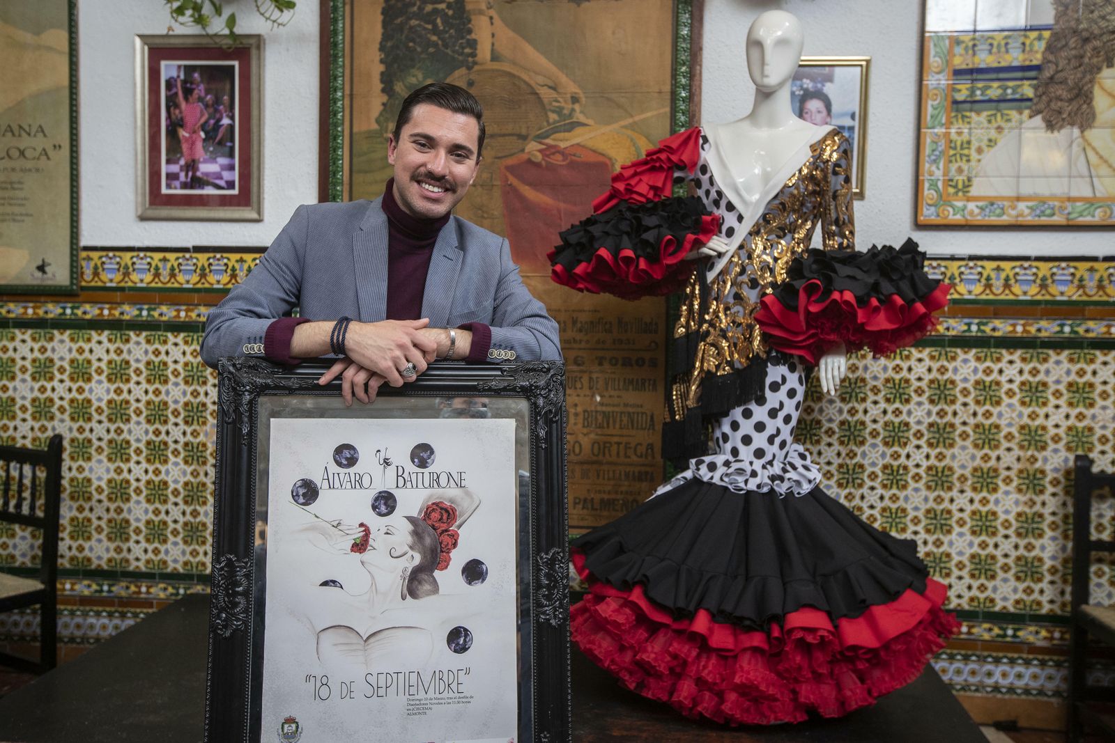 Álvaro Baturone posa con el cartel de su colección y uno de los trajes.