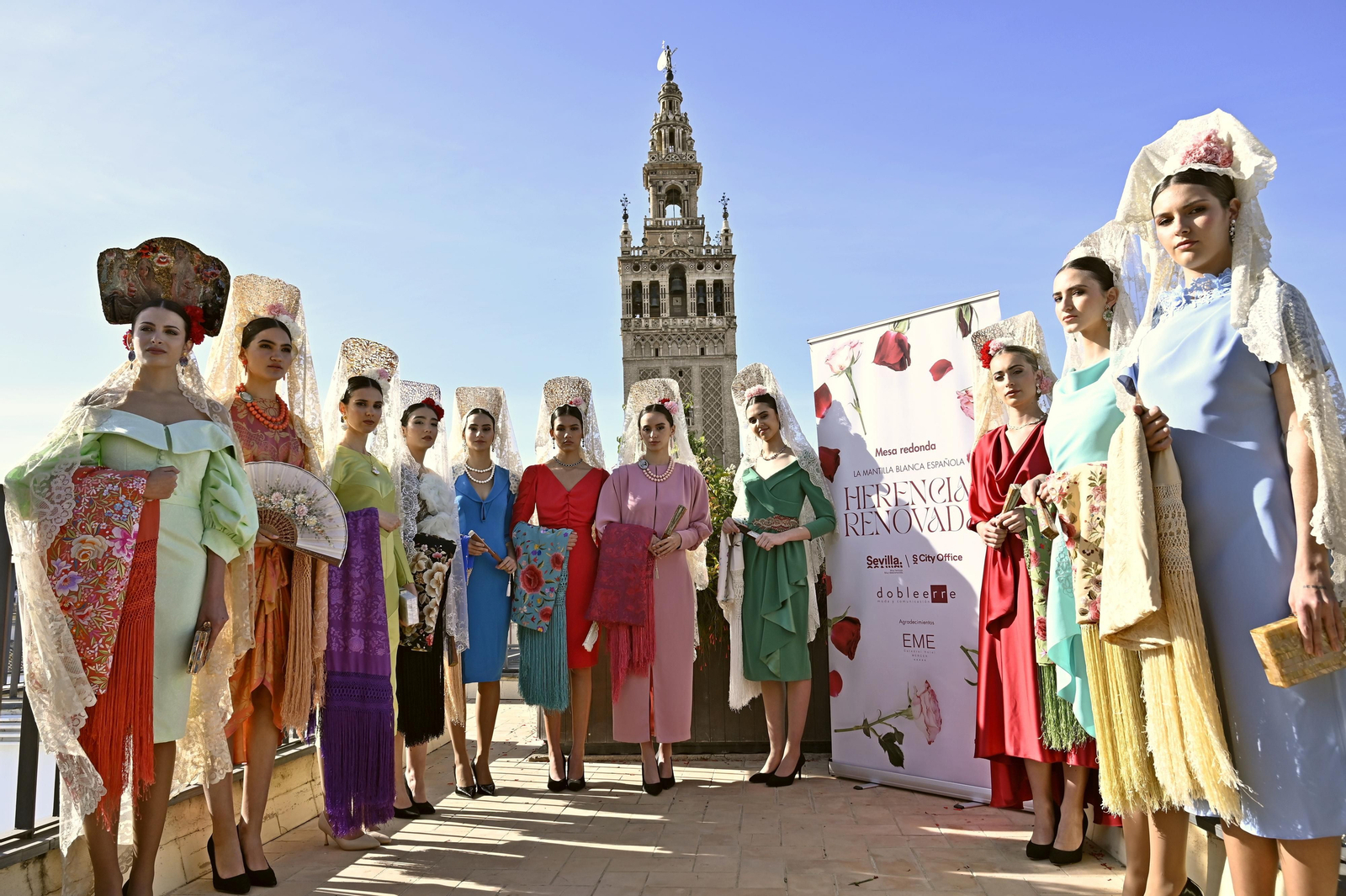 Jóvenes de mantilla posan con la Giralda de fondo. Jóvenes de mantilla posan con la Giralda de fondo.