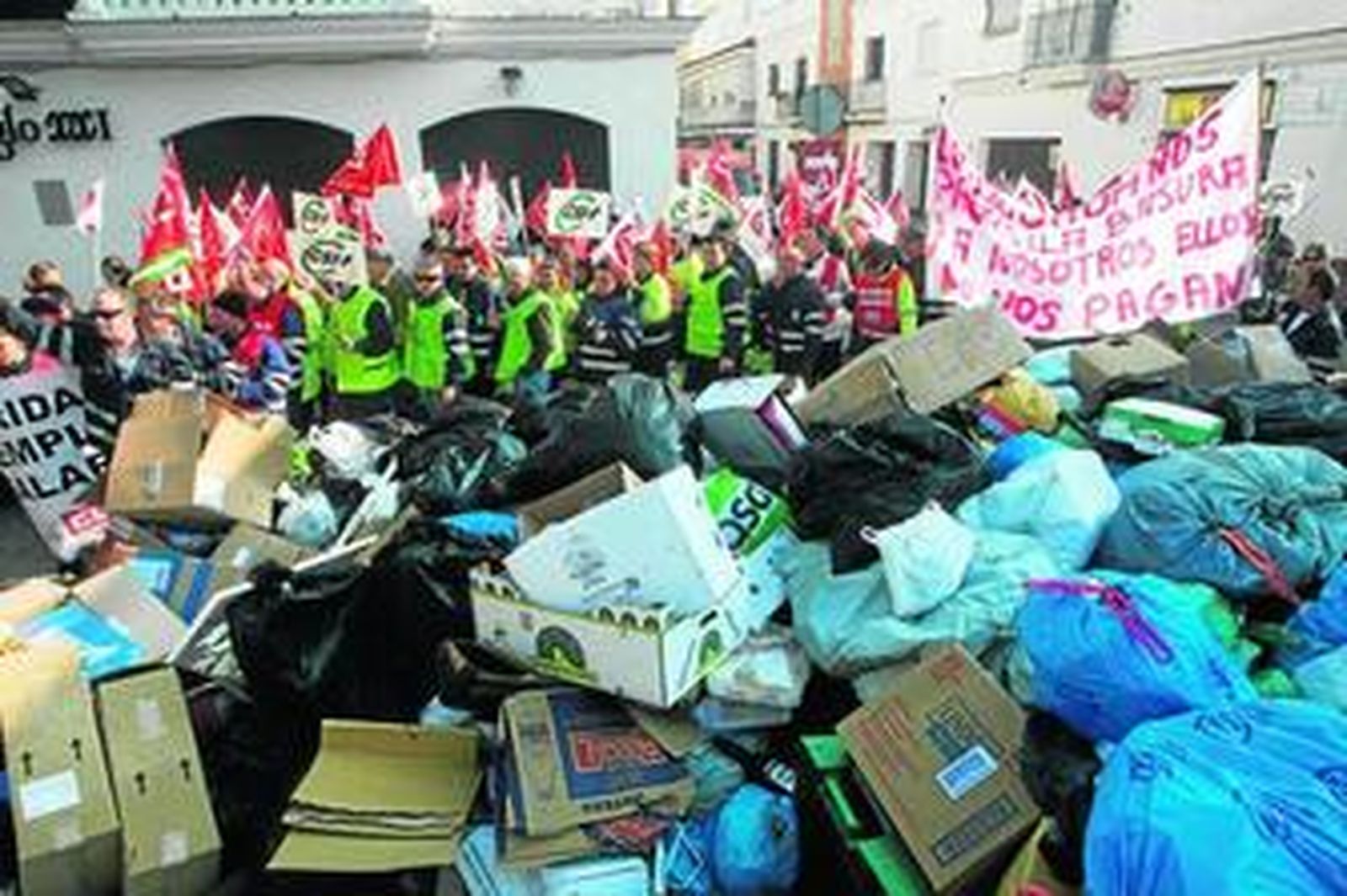 Protesta de los trabajadores del servicio de basuras de Chipiona, en una imagen del pasado jueves, junto a una montaña de desperdicios.