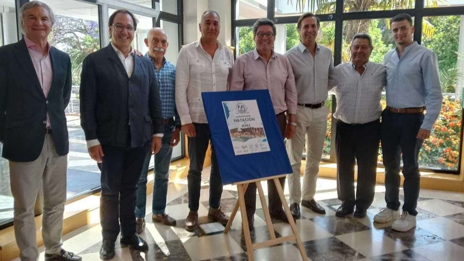 Los asistentes al acto de presentación del 55 aniversario de la natación Jerez posan con el cartel de los actos programados.