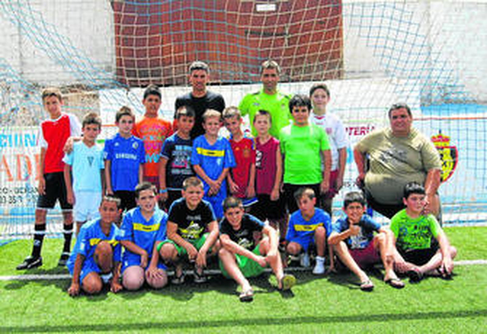 Los hermanos Sevilla, Salva y José, posan con los chavales del campus de fútbol de Berja.