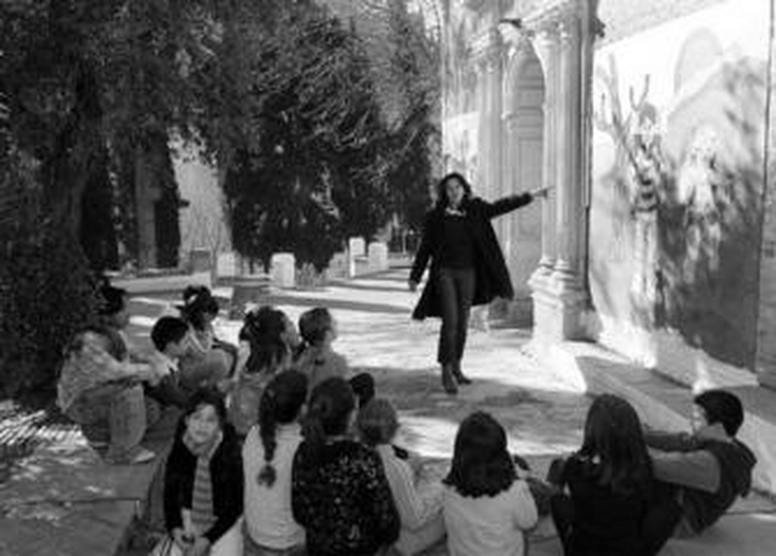 En la imagen inferior, la misma perspectiva pero en la actualidad. La mujer se integra a la docencia y es una maestra la que hace preguntas sobre un mural a su grupo de alumnos.