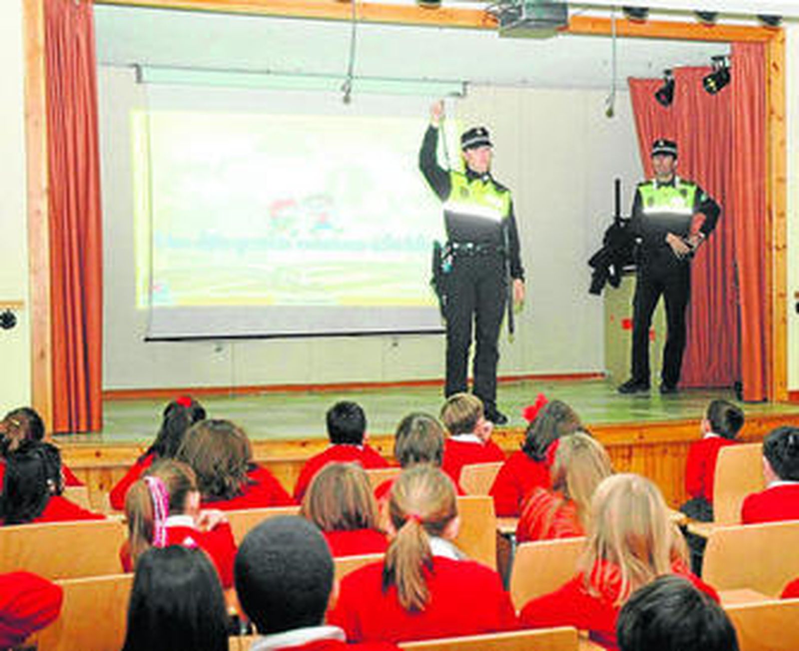 Los escolares asisten interesados a las clases que imparten los agentes.