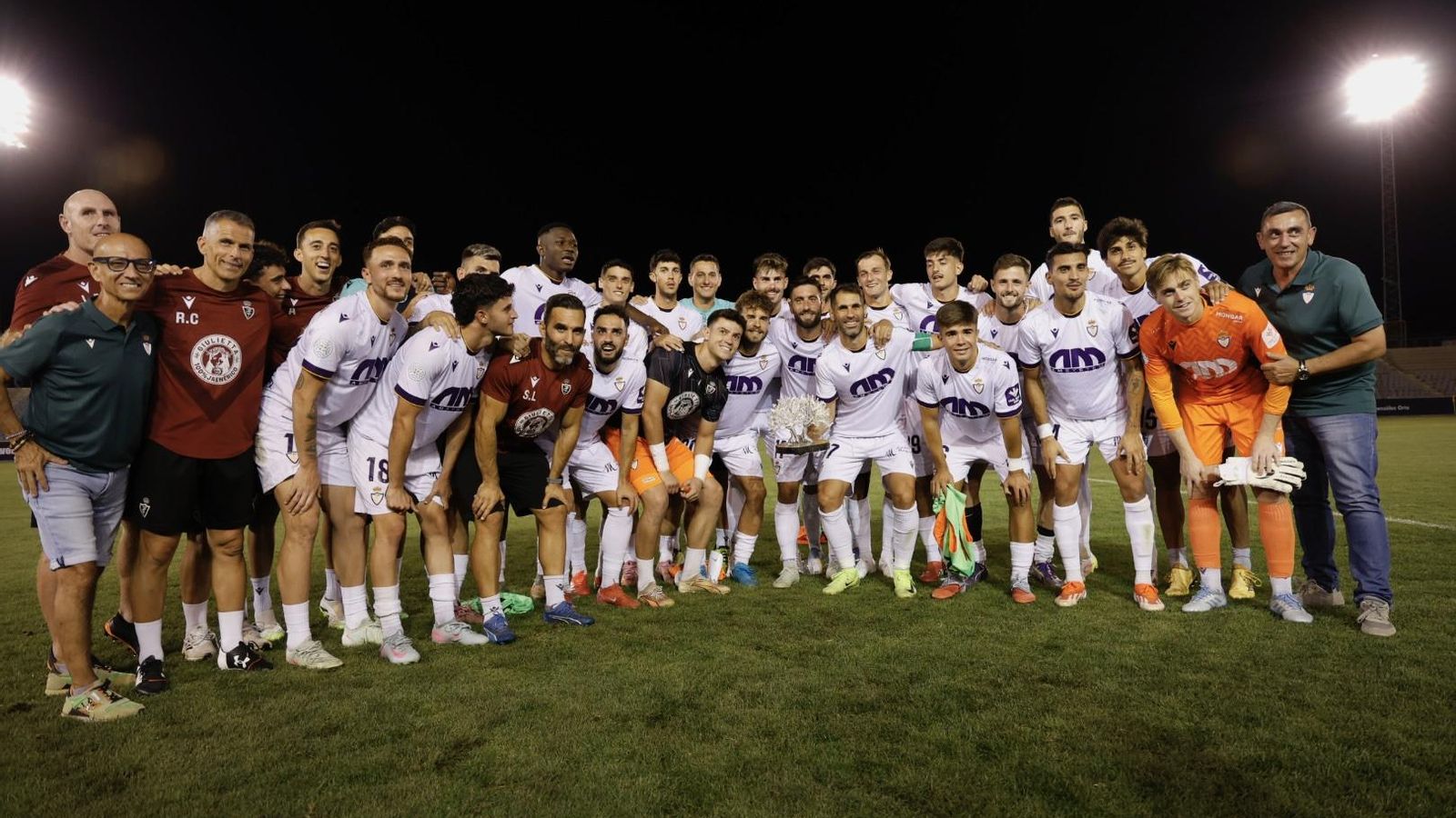 El Real Jaén posa con el Trofeo del Olivo en el terreno de juego.