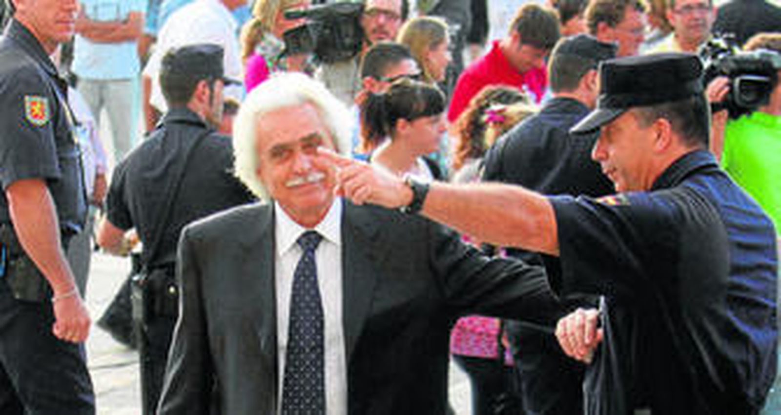 Un policía indica el camino a Rafael Gómez a su llegada al juicio por el caso Malaya, en Málaga.