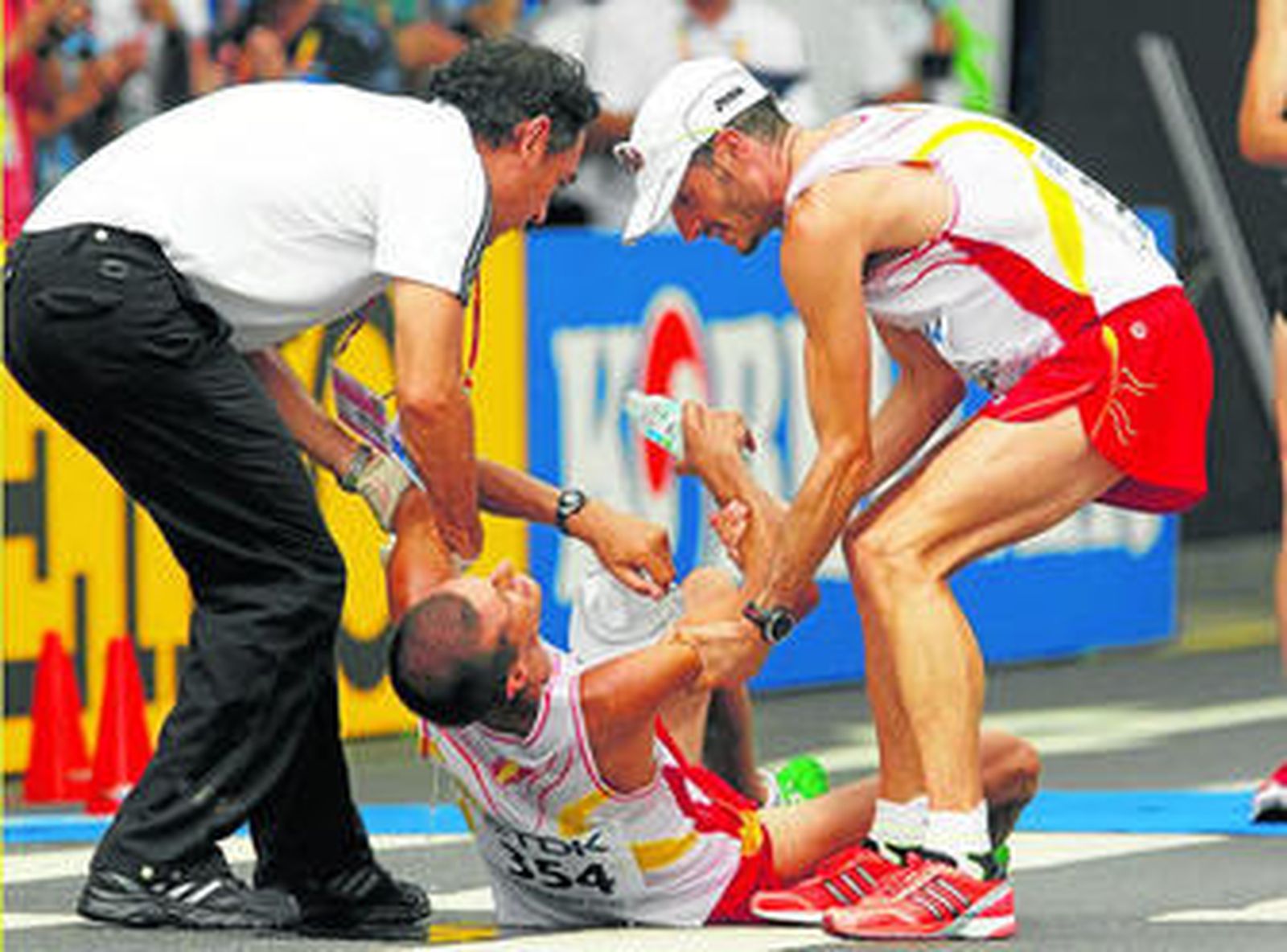 El maratoniano Pablo Villalobos es ayudado por su compañero Rafael Iglesias y un comisario.