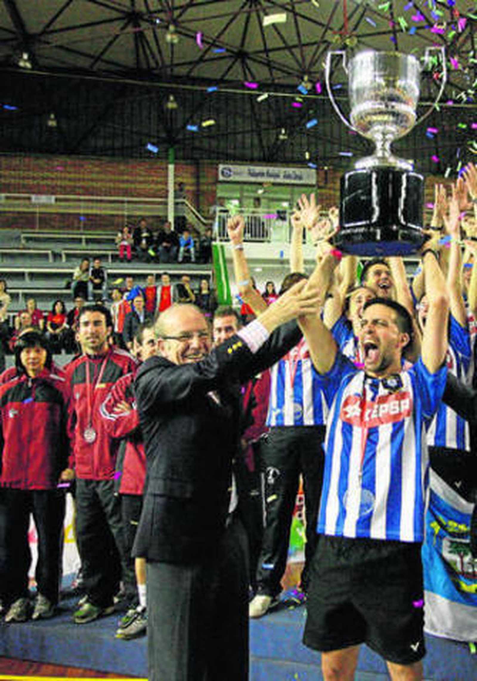Los jugadores del Rinconada observan a Longo levantar el trofeo de campeón.