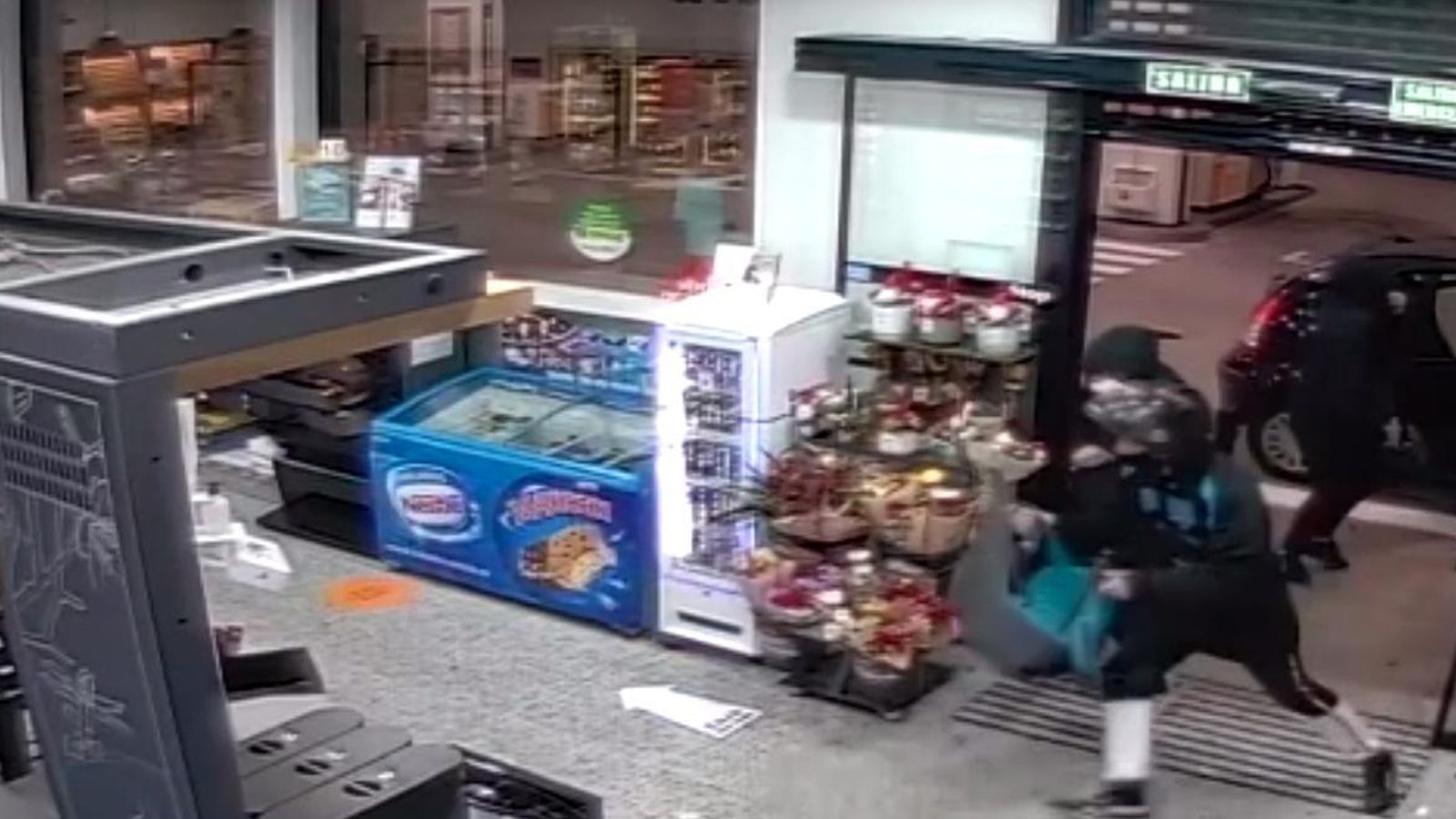 Uno de los asaltantes irrumpe en la gasolinera con un pasamontañas