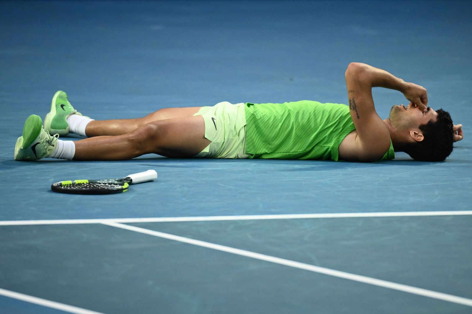 Carlos Alcaraz exhausto sobre la pista tras conseguir meterse en la final del Open de Australia.