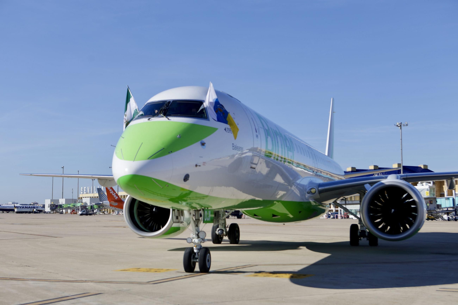 Aterrizaje del primer vuelo en Sevilla con las banderas de ambas comunidades