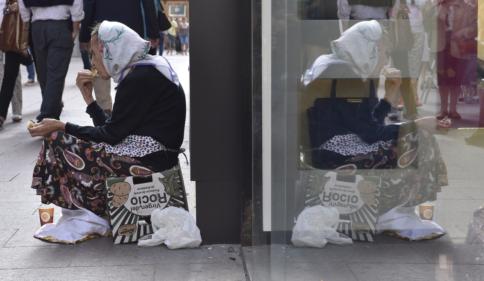 Una mujer pide limosnas en una céntrica calle de la ciudad.
