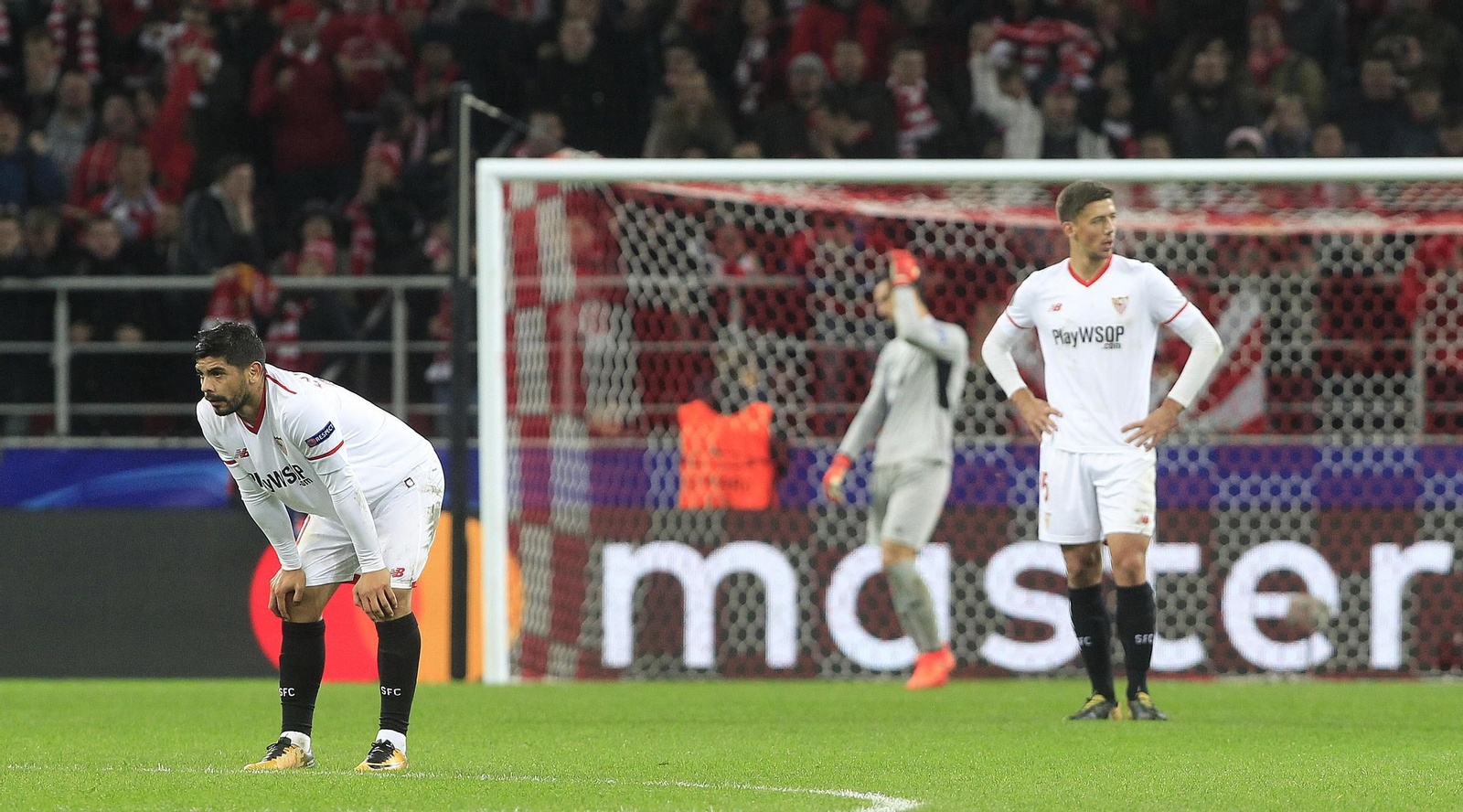 Banega, Lenglet y Sergio Rico, al fondo,  con gestos contrariados tras encajar uno de los goles.