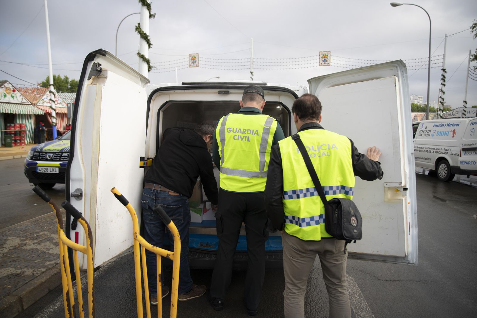 Agentes de la Guardia Civil y la Policía Local inspeccionan un vehículo con alimentos antes de entrar en la Feria.