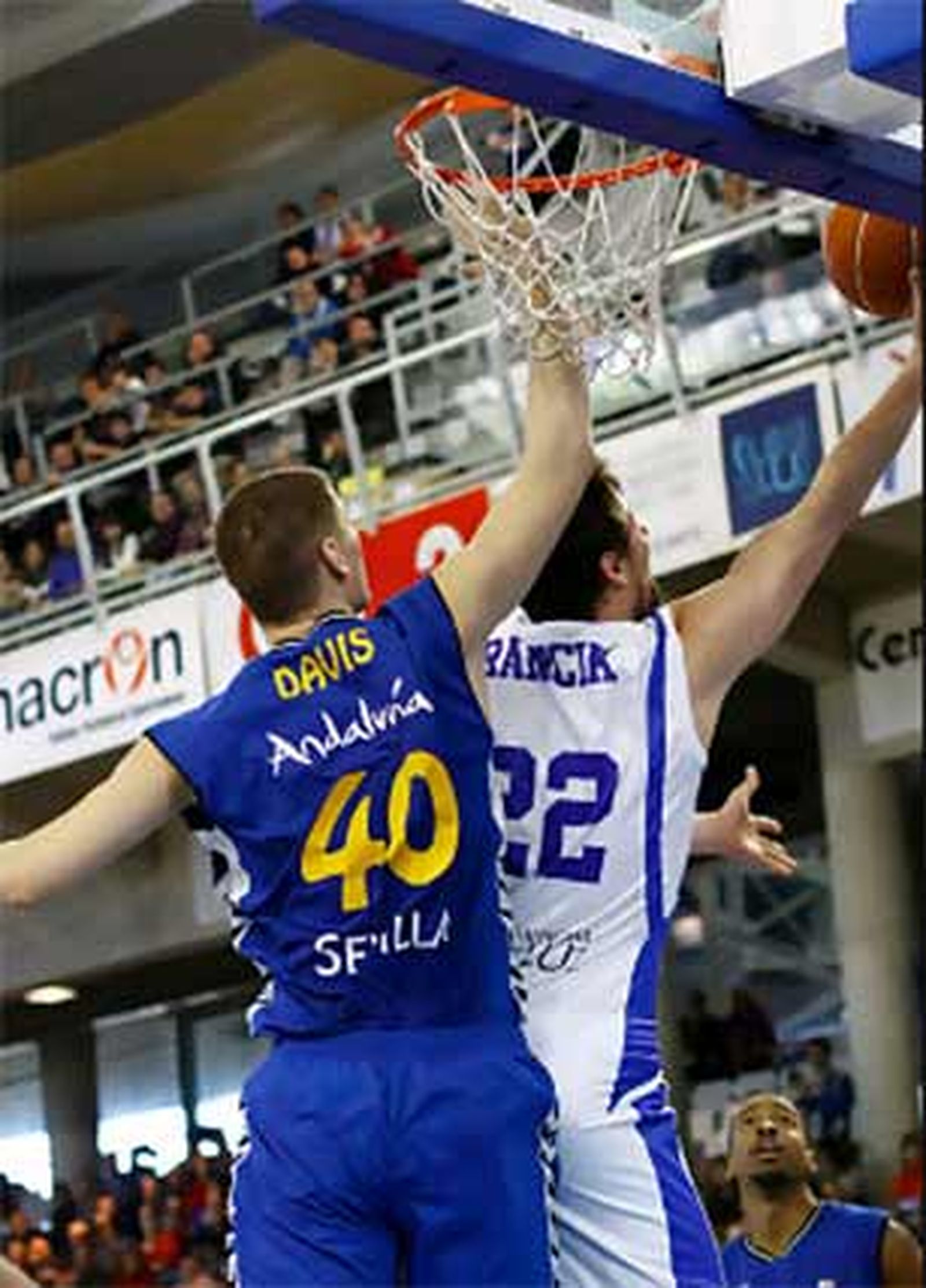 Martin Rancik busca la canasta a aro pasado, adelantándose a Paul Davis

Foto: Javier Bernal