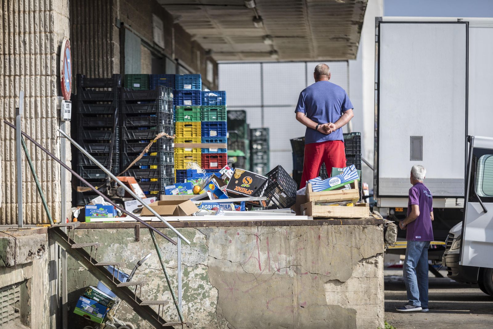Dos trabajadores operan en la lonja de frutas.