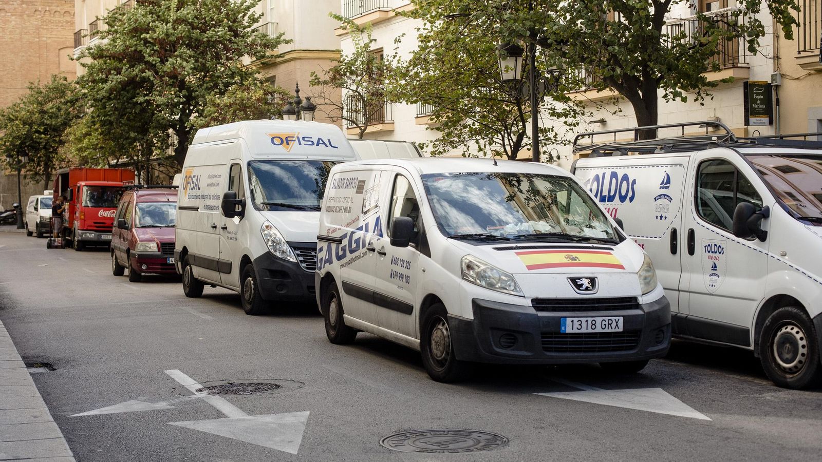 Camionetas de reparto en doble fila en la calle Lázaro Dou.