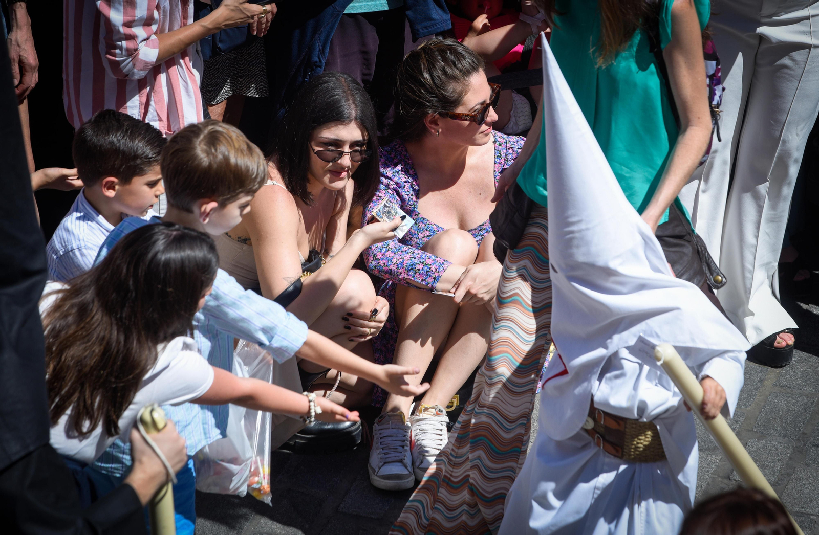 Niños piden caramelos en la salida de la Borriquita.