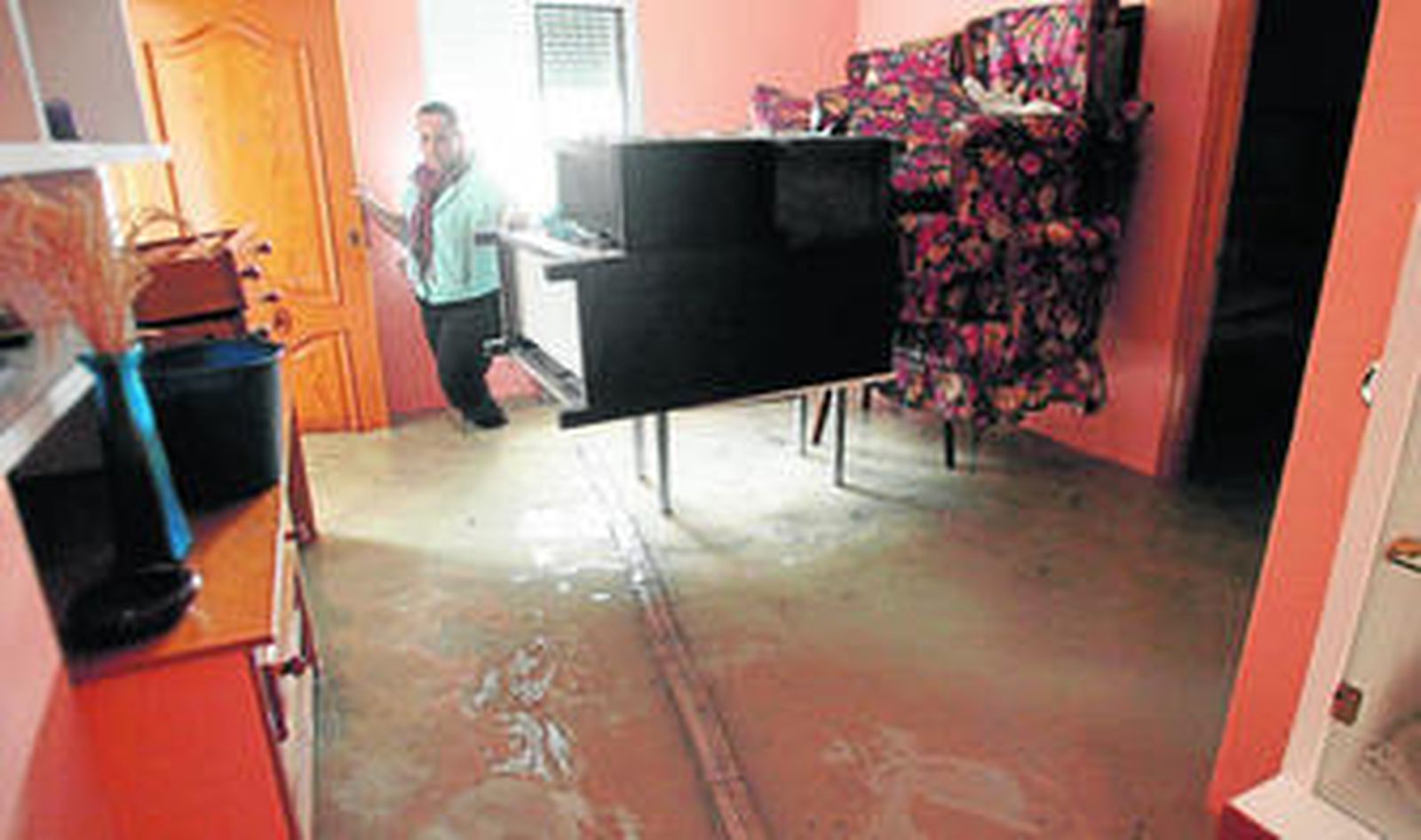 El agua inunda el por completo el salón de una vivienda, en la calle León XIII.