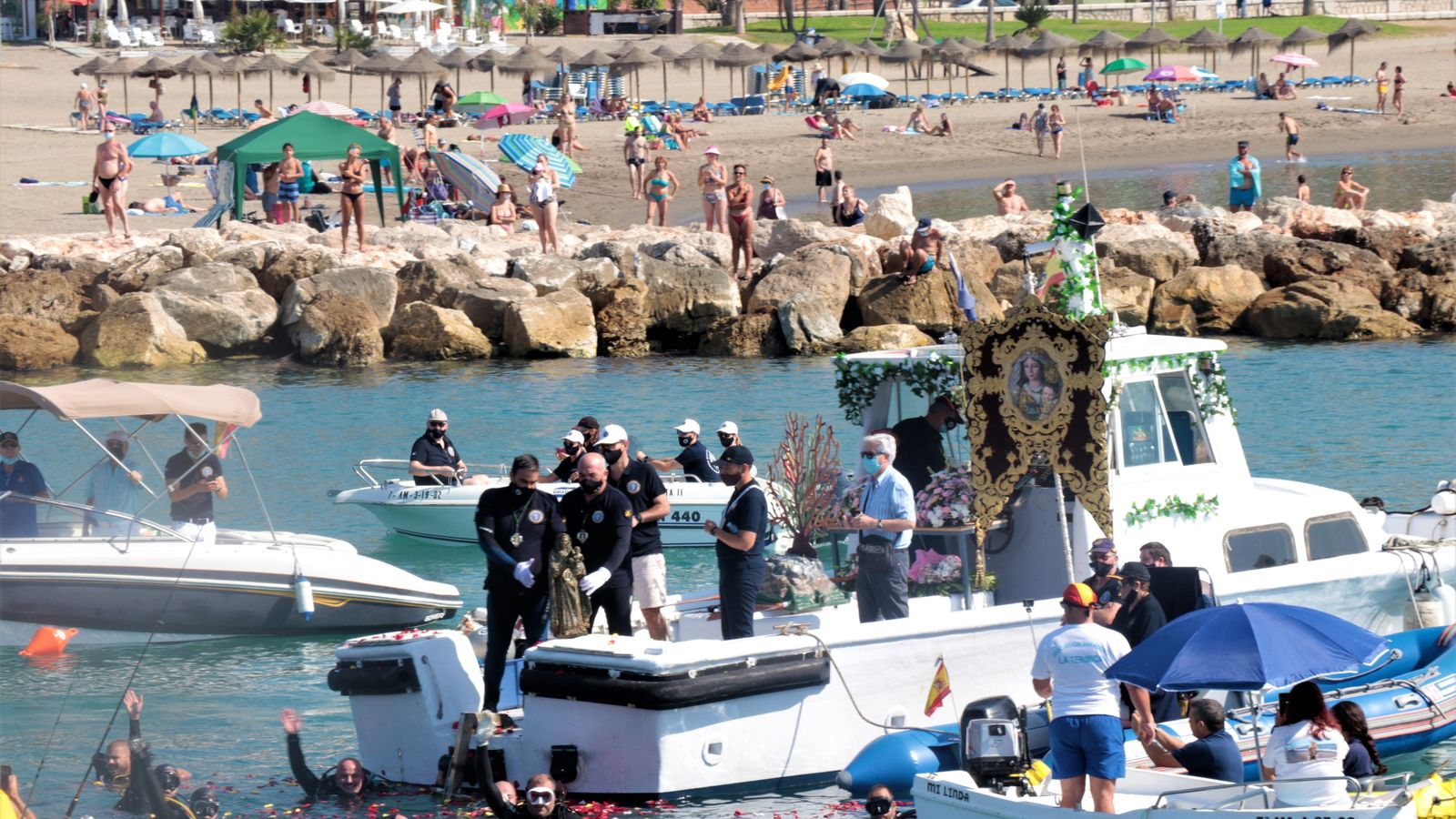El estandarte del Carmen del Perchel y la virgen de los Submarinistas en la barca.