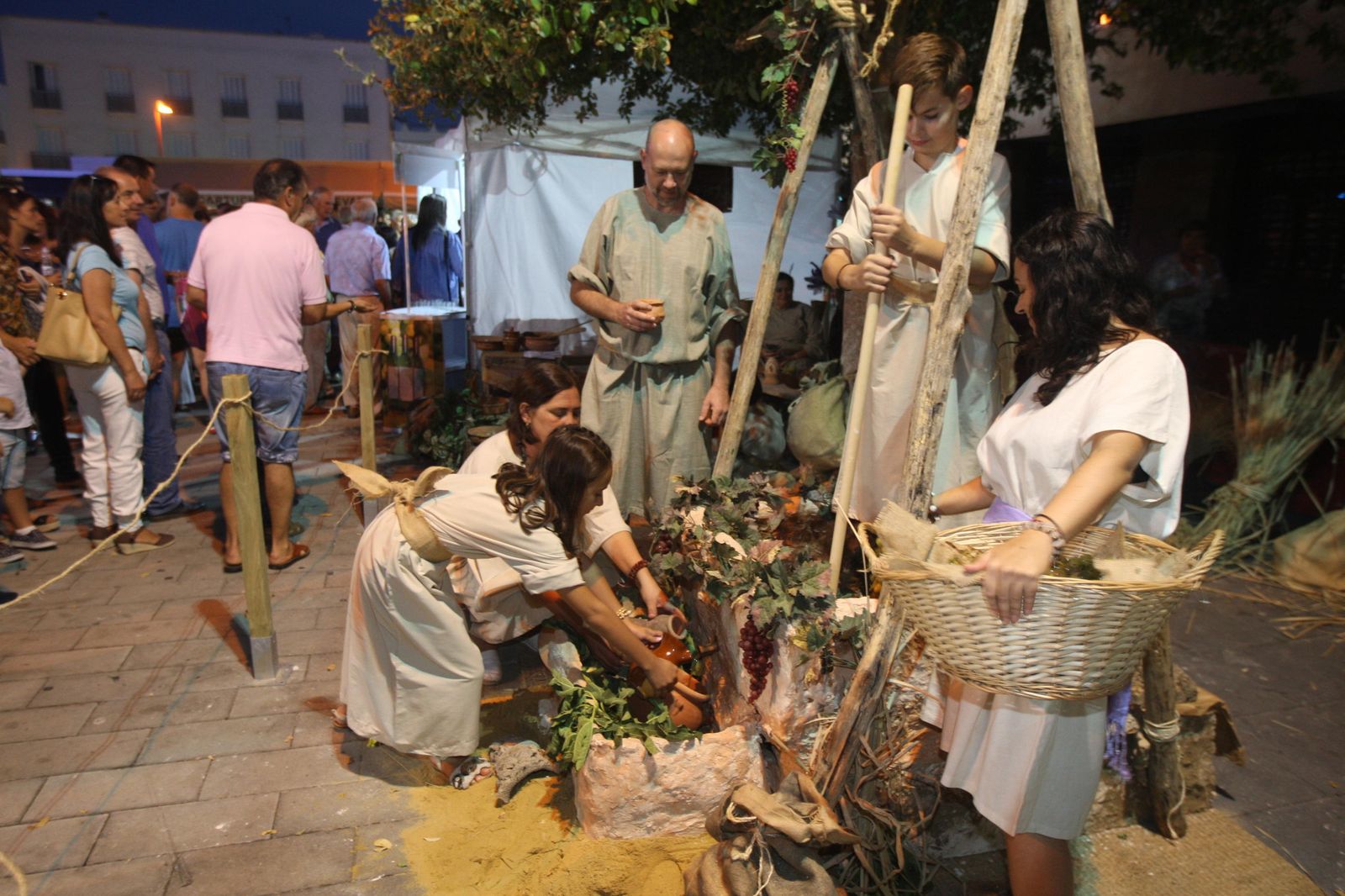 Recreación histórica con figurantes frente a una réplica de un lagar fenicio-púnico