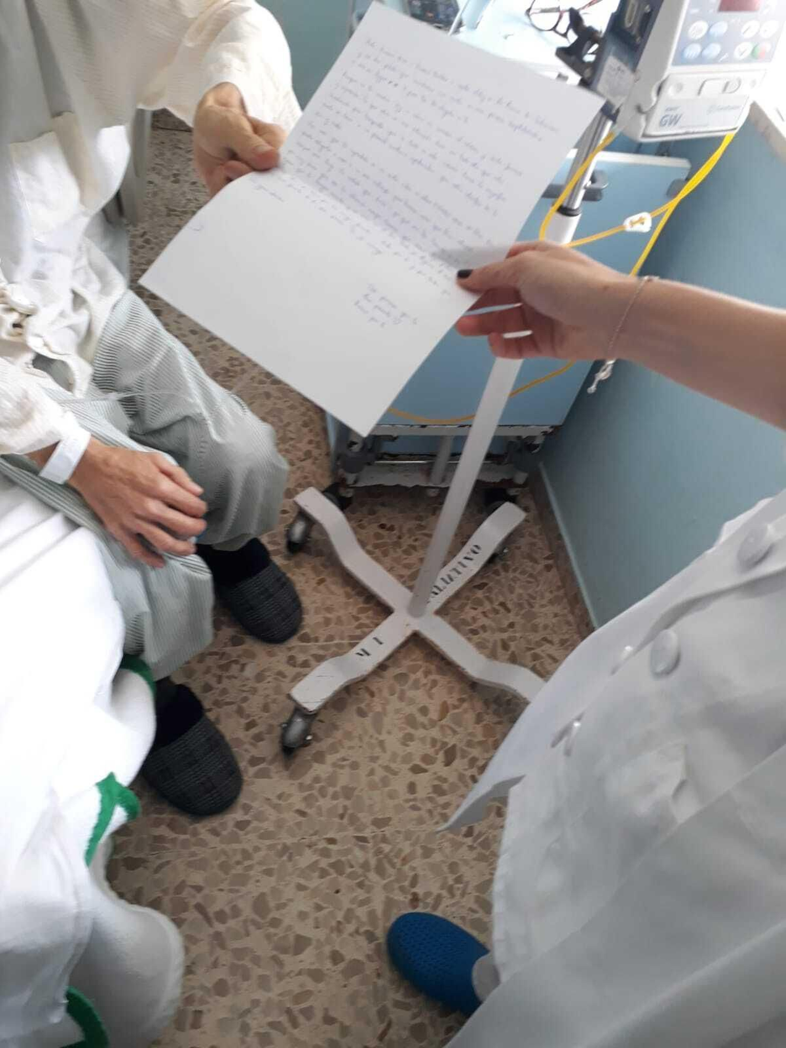 Un paciente del hospital recoge una de las cartas escritas por jóvenes de Salesianos.