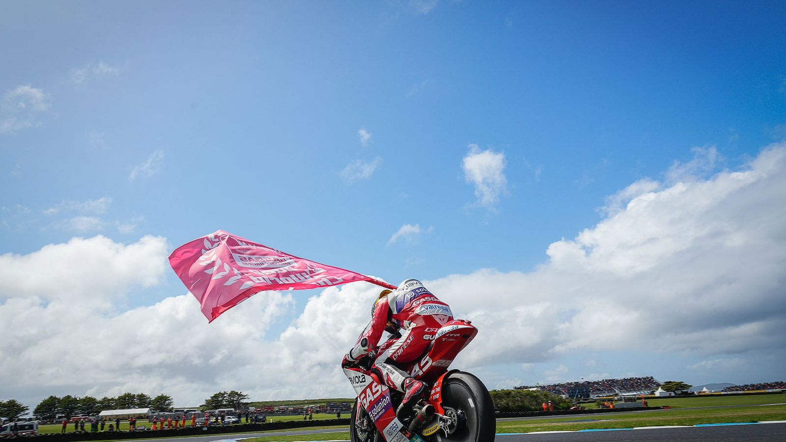 El nuevo campeón de Moto3 ondea un bandera.