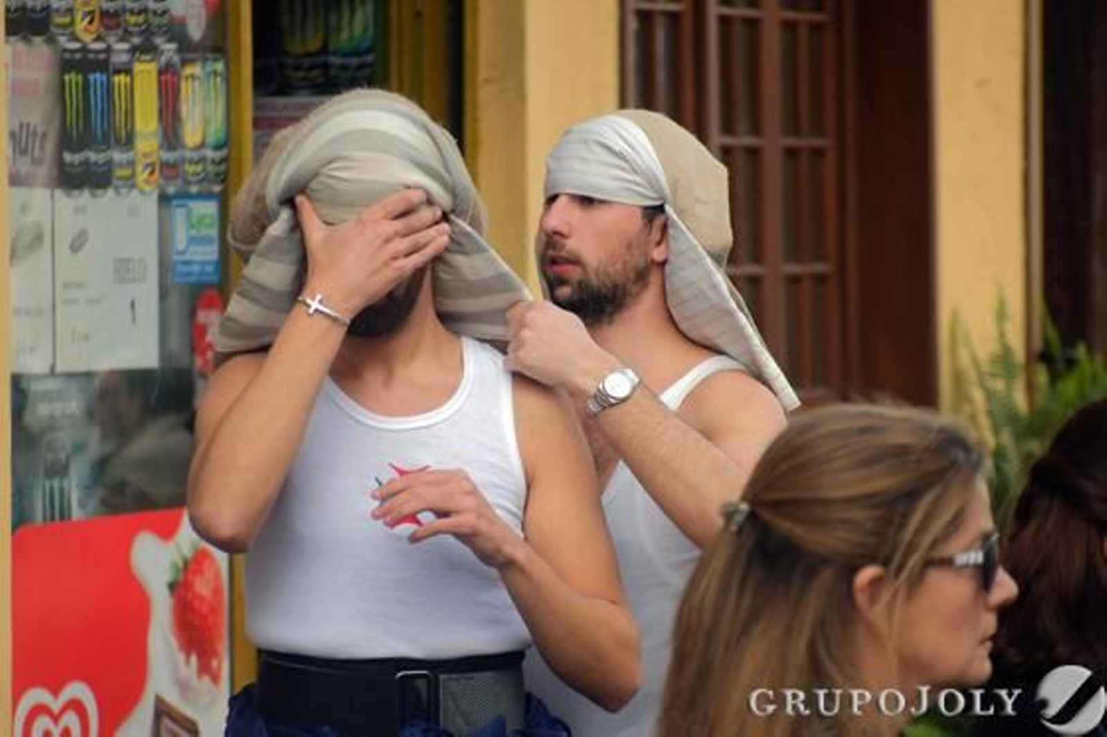 Un costalero de Humildad y Paciencia ayuda a otro a ponerse el costal.

Foto: Manu Garcia