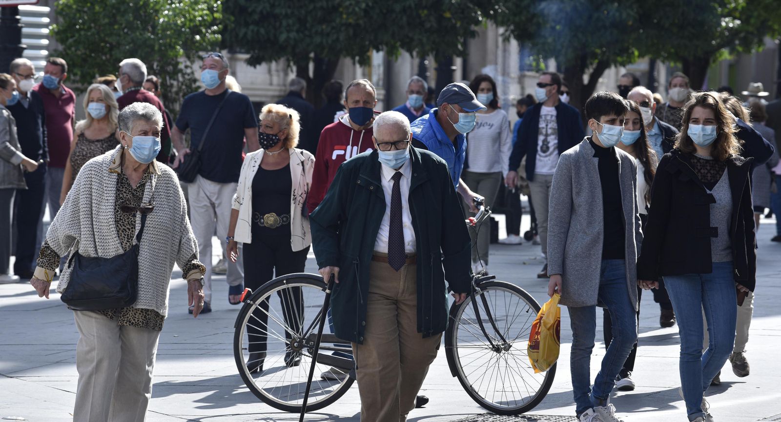 Gente con mascarilla paseando por las calles de Sevilla.