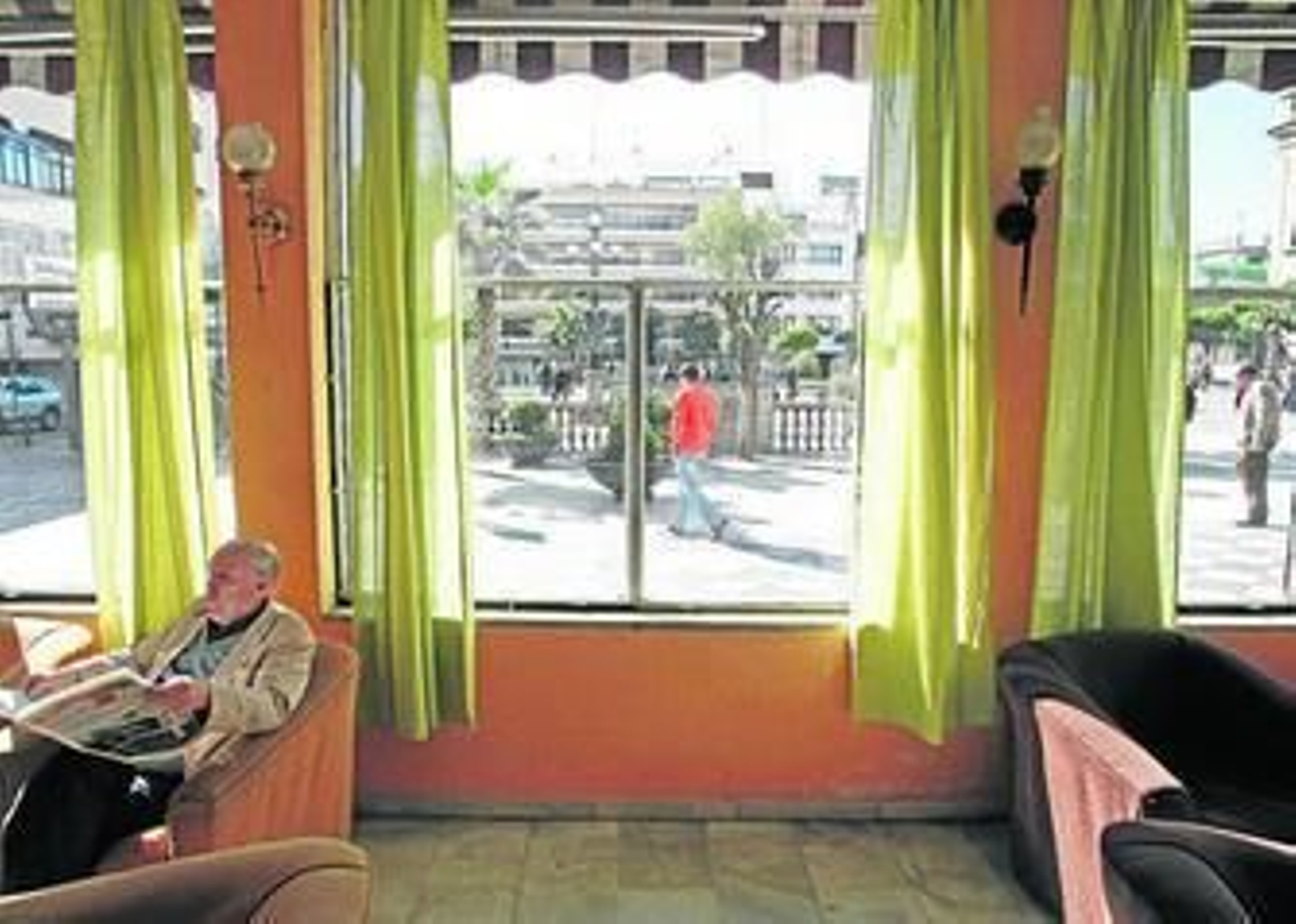 Un socio del Casino lee la prensa en el salón noble, local que se ofrece en alquiler.