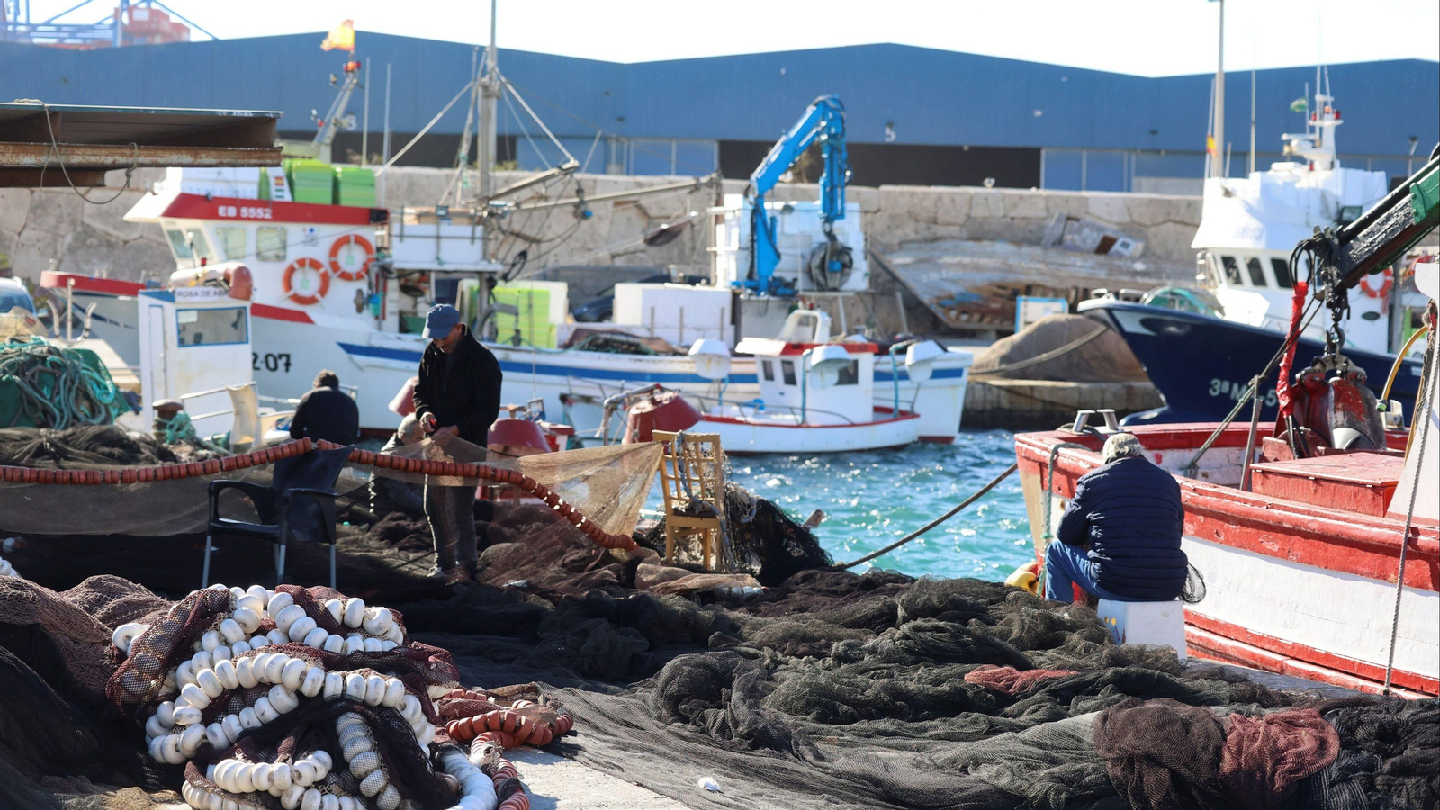 Pescadores reparando sus redes de pesca en el puerto de Málaga.