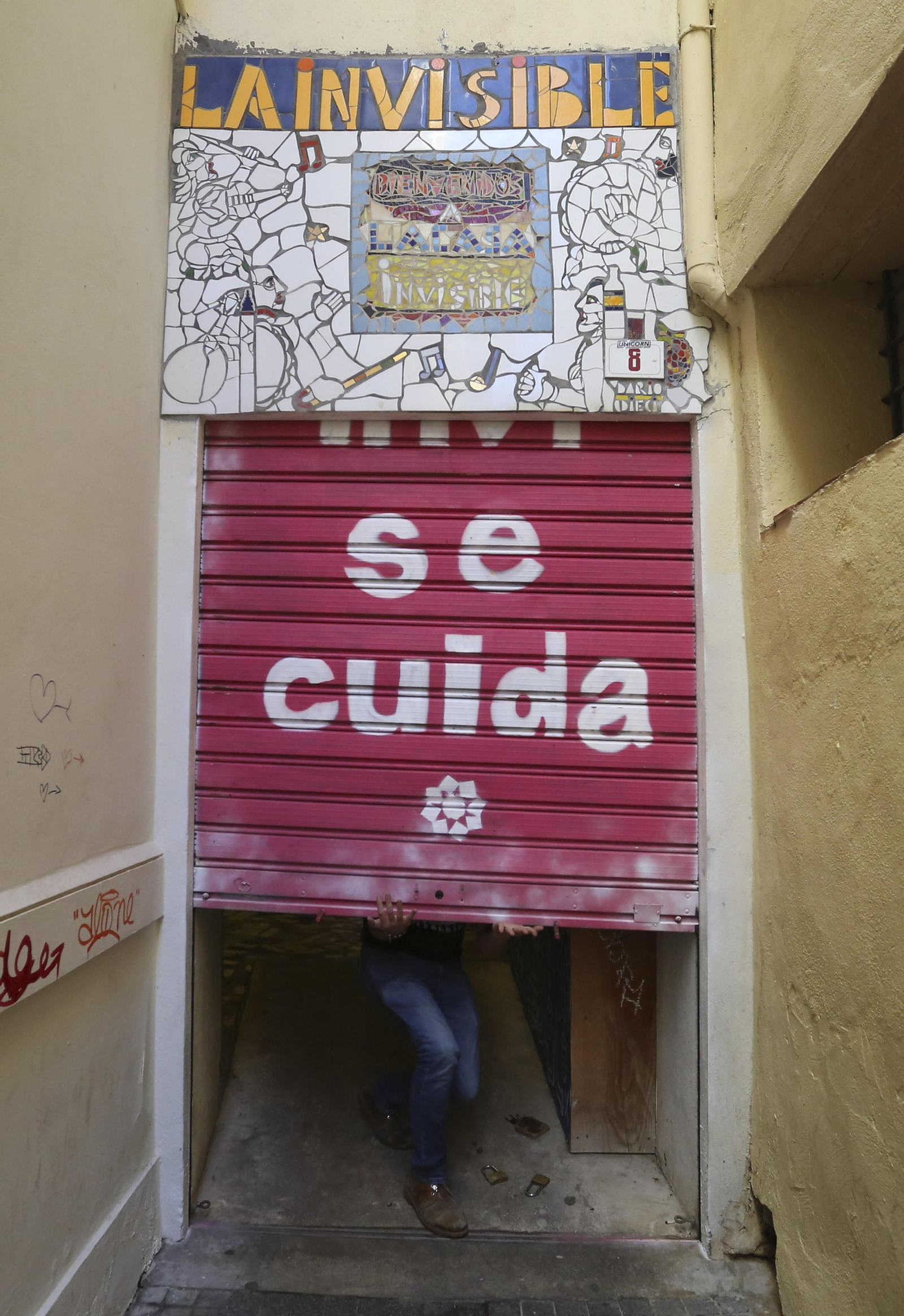 Uno de los voluntarios abre la verja de La Invisible.