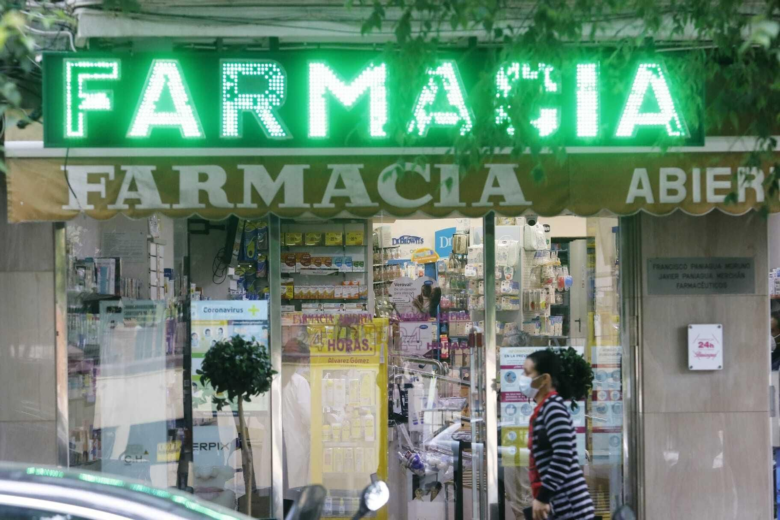 Una mujer pasa delante de una farmacia de la avenida Gran Vía Parque de Córdoba.