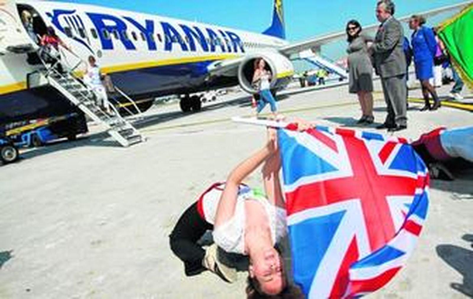 Los usuarios del avión de Ryanair procedente de Liverpool arriban en Málaga mientras son recibidos por una panda de verdiales, ayer.