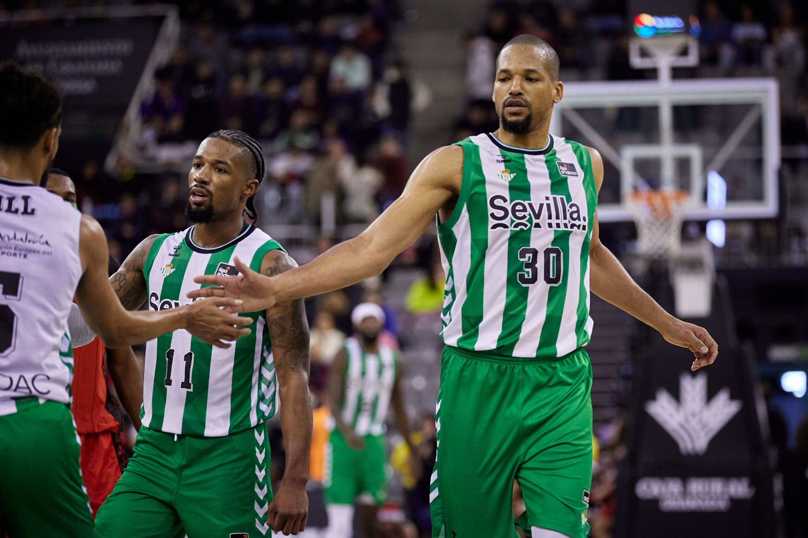 Báez saluda a Hill en presencia de Evans durante el encuentro ante el Granada.