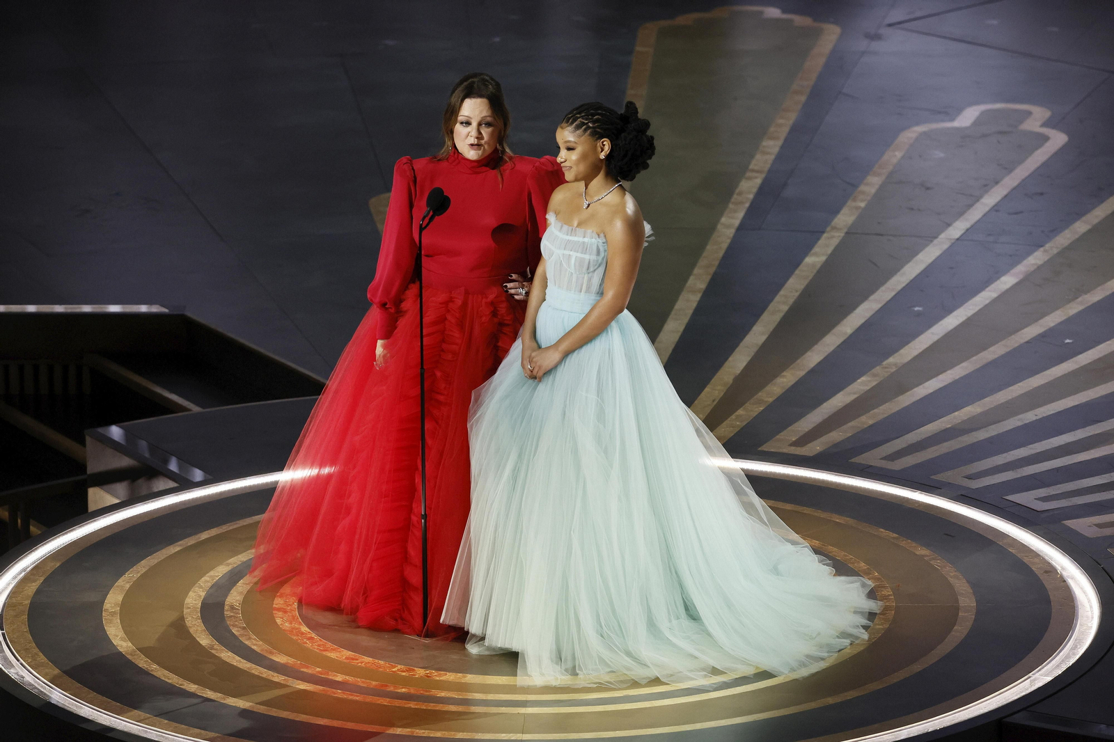 Melissa McCarty, a la izquierda, y su ampuloso vestido rojo hasta el cuello