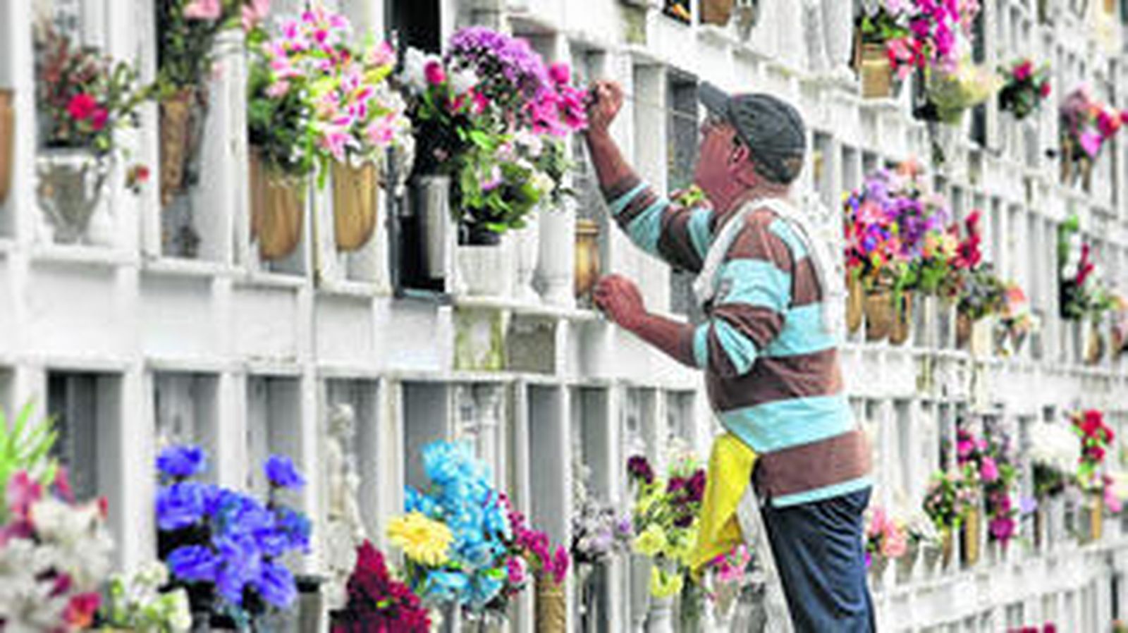Un hombre ultima el repaso de una lápida en el cementerio municipal portuense, que recibe estos días cientos de visitas.