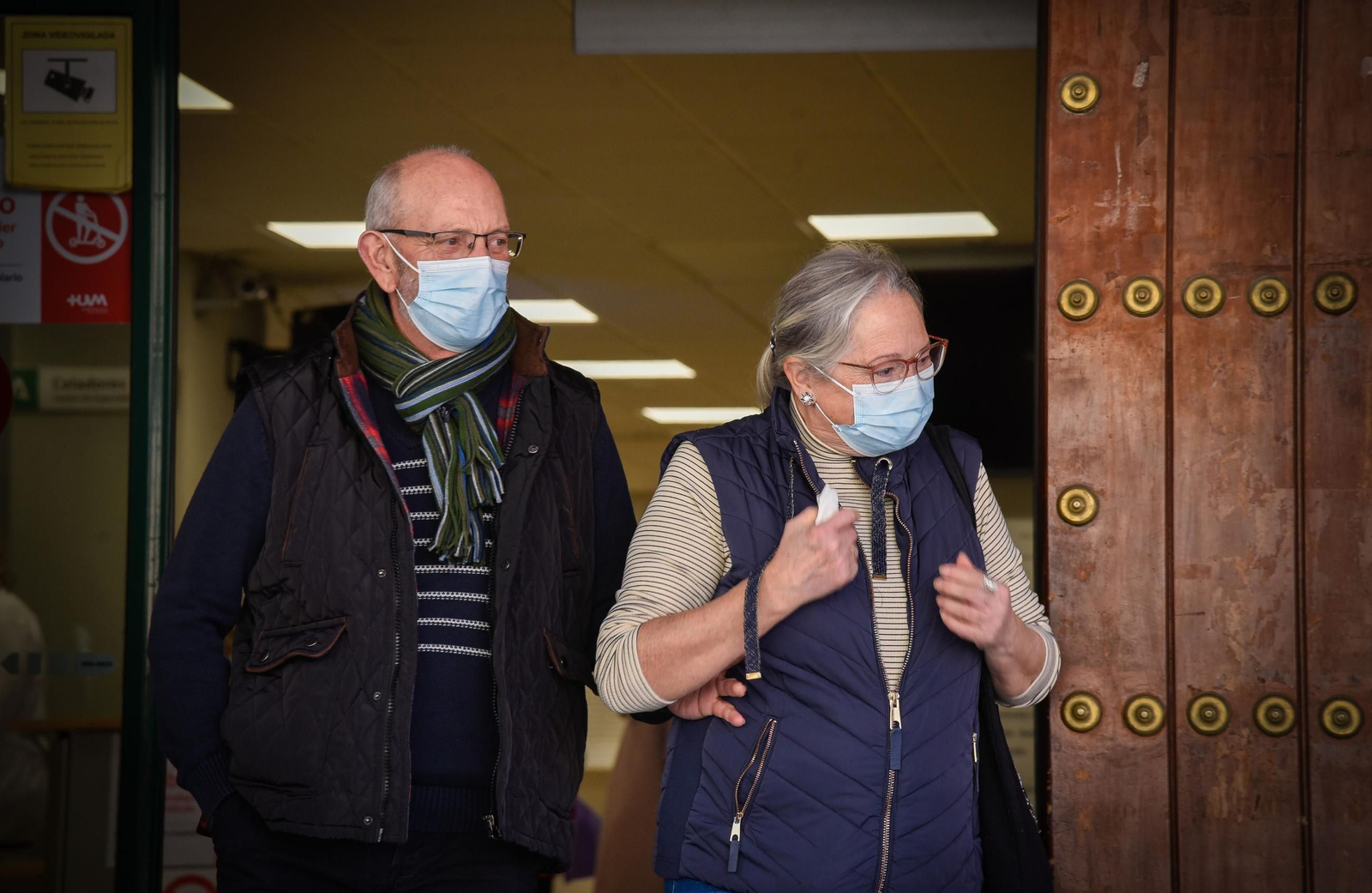 Dos personas se protegen con mascarilla en el entorno de un centro sanitario en Sevilla.